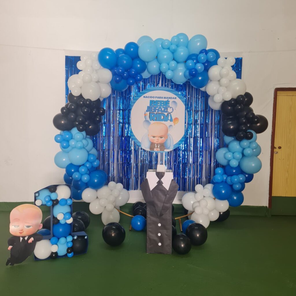 Decoración con globos para fiesta infantil con tema bebé jefe. Creación colorida con globos azules, blancos, negros y elementos decorativos en tonos alegres y llamativos. Perfecta para cumpleaños y eventos infantiles.